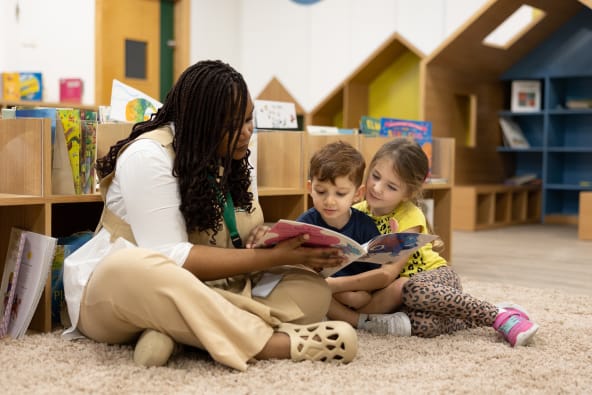 A woman reading to children in a classroom.