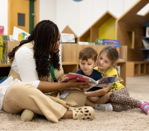 A woman reading to children in a classroom.